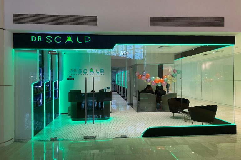 DrScalp clinic entrance featuring modern design, neon lighting, and promotional balloons, emphasizing innovative hair and scalp solutions.