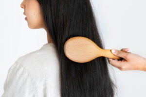A woman hair getting combed representing how to stop balding