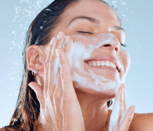 A woman cleansing her face using face wash