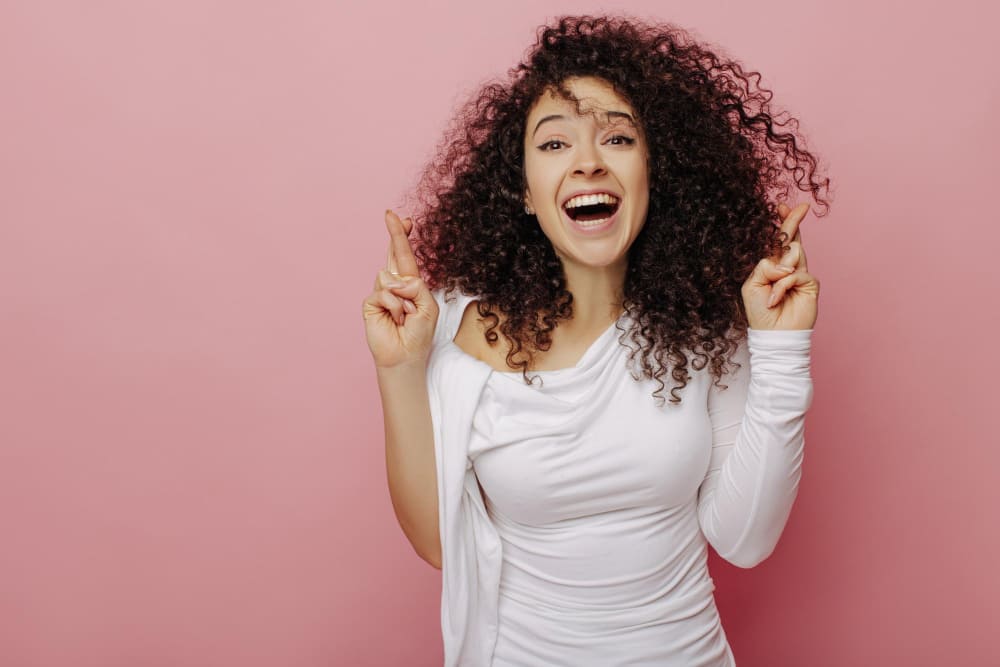 A woman with curly hair smiling after using the best diffusers for curly hair