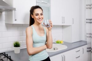 A woman in sportswear drinking water