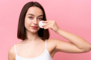 A woman with a cotton pad for removing makeup