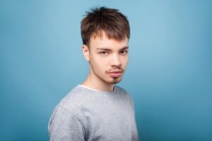 A young man with thin facial hair