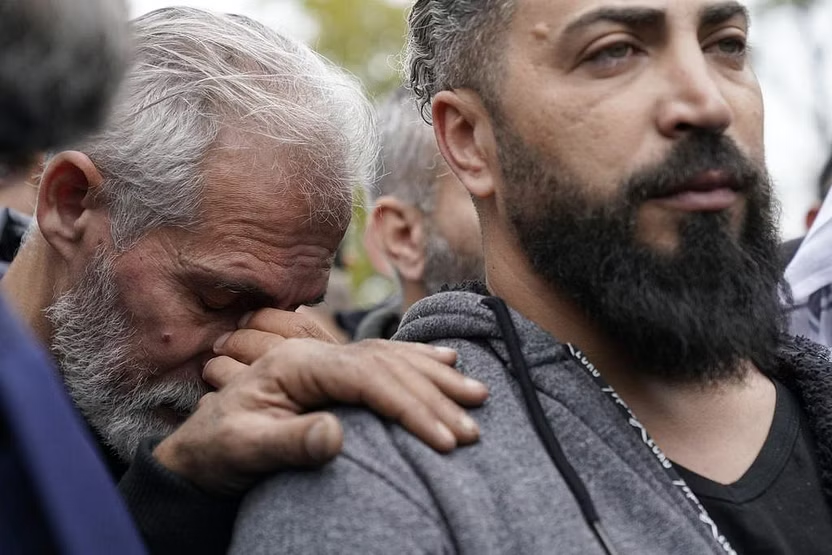 Wadea Al Fayoume's father, Oday Al Fayoume, right, and his uncle Mahmoud Yousef mourn at Wadea's grave in LaGrange, Illinois after the attack, Monday, Oct. 16, 2023. (AP) 
