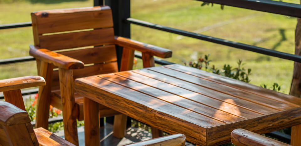 A wooden table and set of chairs in a garden finished with JAT masters coating