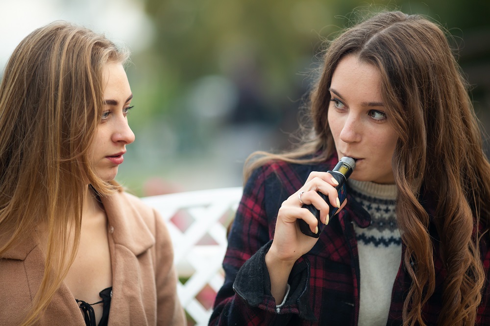 Teenage girls, one vaping