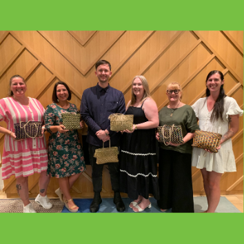 Six award recipients holding kete