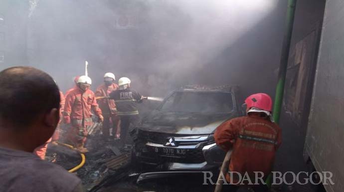 petugas damkar memadamkan api mobil di Tomang