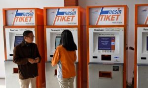 Petugas membantu salah satu warga yang akan membeli tiket kereta api (KA) dengan menggunakan mesin khusus di Stasiun KA Pasar Senen, Jakarta, Senin (18/11/2019). 