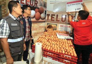 PANTAU BAHAN POKOK: Anggota Satgas Pangan ketika mengawasi karyawan salah satu retail modern mengganti label harga telur yang dijual beberapa waktu lalu. 