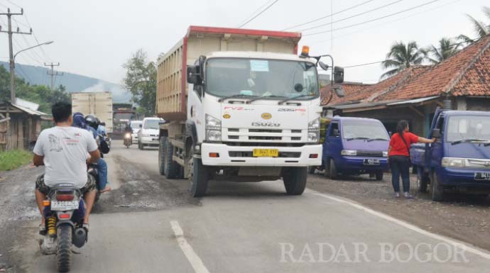 Hendinovian/radarbogor DIKELUHKAN: Truk tambang melintasi Jalan Raya Cigudeg, Kecamatan Cigudeg, Kabupaten Bogor. Kian hari keberadaan truk yang membawa material tambang semakin banyak dan membuat masalah baru. 