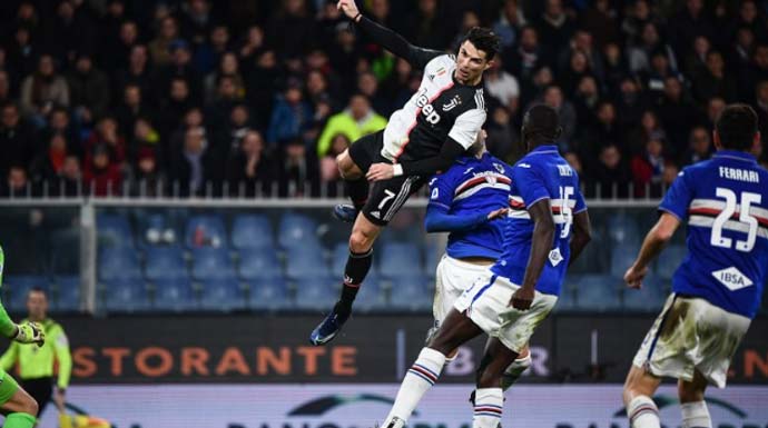 Penyerang Juventus Cristiano Ronaldo (tengah) menanduk bola untuk menjadi gol penentu kemenangan dalam pertandingan Liga Italia melawan Sampdoria yang dimainkan di Stadion Luigi Feraris, Genoa, Rabu (18/12/2019). (ANTARA/AFP/MARCO BERTORELLO)