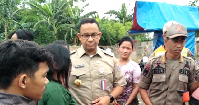 Gubernur DKI Jakarta Anies Baswedan turun dari perahu karet setelah mendengar warga meminta bantuan evakuasi untuk anggota keluarga untuk cuci darah. Foto: (ANTARA/DEVI NINDY