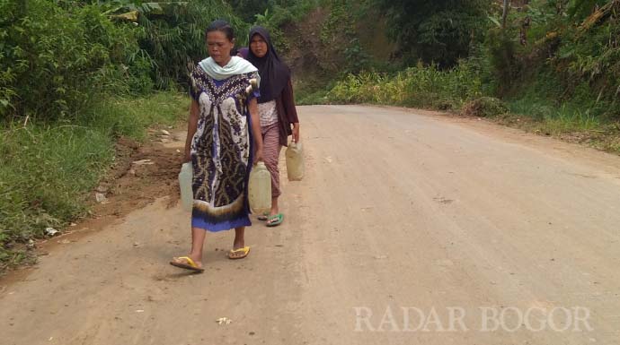JALAN KAKI: Sejumlah warga terdampak bencana di Sukajaya saat berjalan kaki untuk mencari air ke kampung lainnya. 