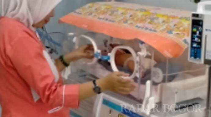 PERAWATAN: Salah satu perawat sedang mengontrol kondisi pasien bayi yang ada di Rumah Sakit Pena 98.