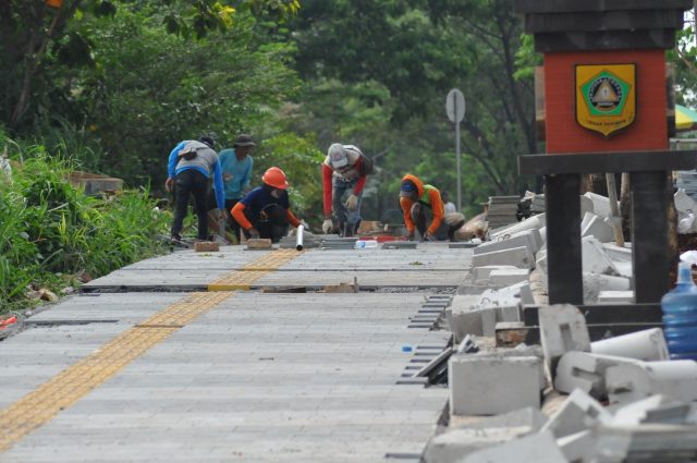 Sejumlah pekerja di pembangunan pedestrian lingkar Pakansari, Cibinong, Kabupaten Bogor, Jawa Barat. Minggu (5/12/2021). Pemkab Bogor terus menyejar sejumlah peningkatan serta pembangunan fasilitas umum di wilayah Cibinong Raya. foto : Hendi Novian / Radar Bogor