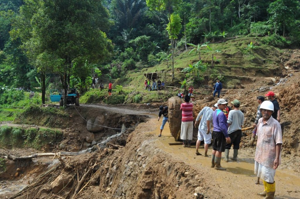 Warga membuka akses jalan yang sempat tertutup material longsor, Pamijahan, Kabupaten Bogor, Jawa Barat pada Rabu (22/6). Akses tersebut kini sudah bisa dilalui kendaraan. Foto : Hendi