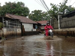 Warga melintasi Jalan Tumenggung Wiradiredja yang selalu banjir jjika hujan. Fatur/Radar Bogor.