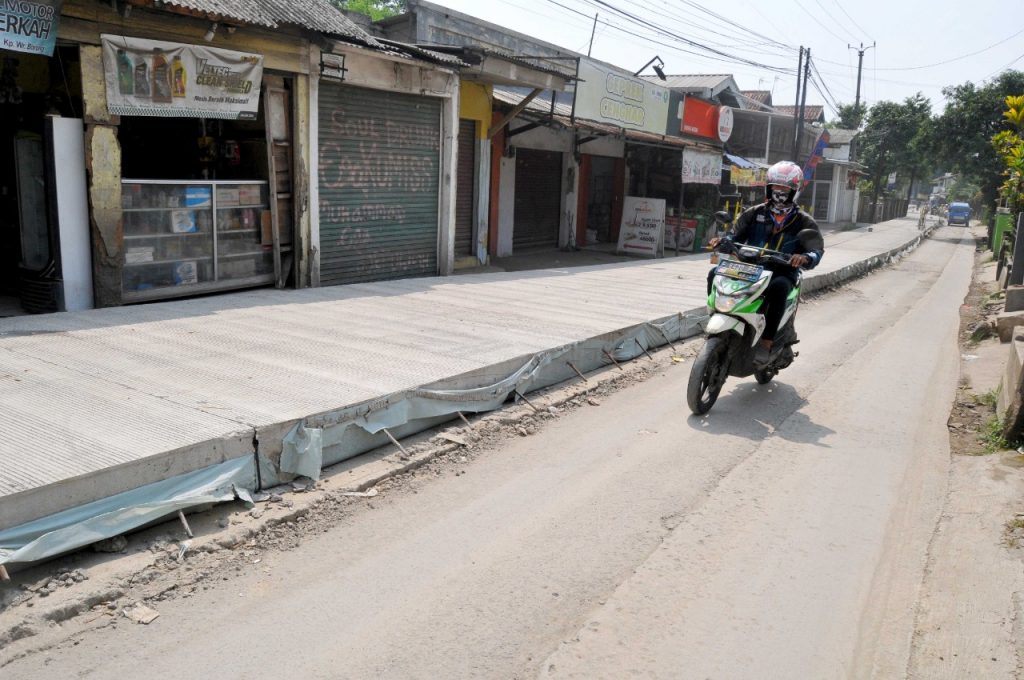 Pengendara melintas di Jalan Warung Borong Rancabungur, Ciampea, KAbupaten Bogor. Kamis (11/8/2022). Peningkatan betonisasi jalan tersebut capai 13,4 persen. Foto : Hendi