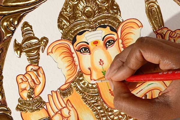 Painting the face of Lord Ganesha on a Tanjore painting with a fine brush