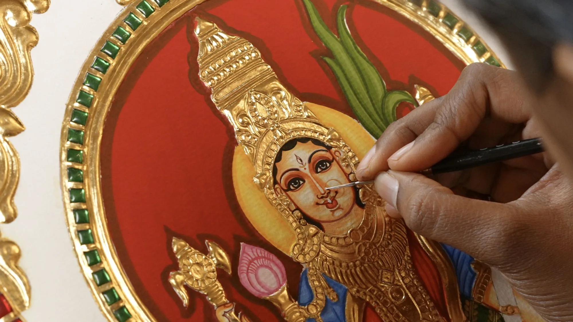 Fine detailing on the face of a Devi in a Tanjore painting