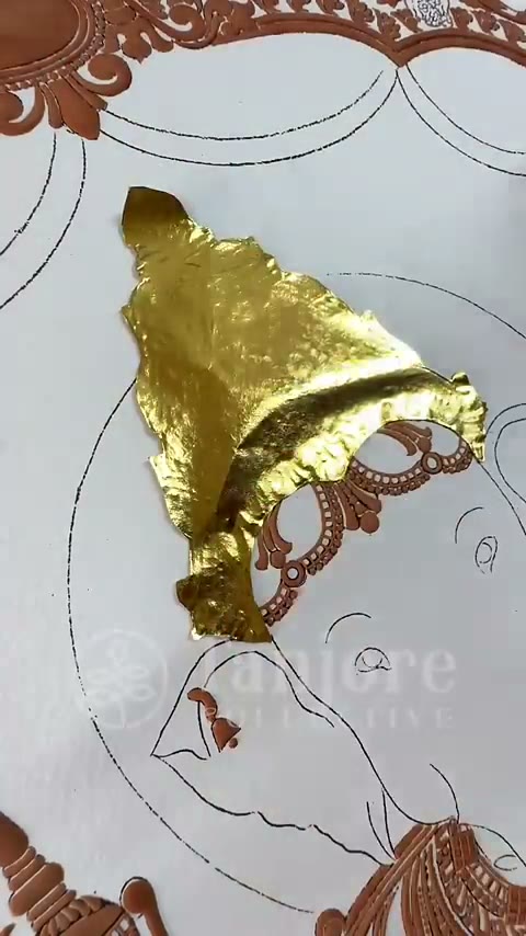 24 karat gold leaf being laid onto a Tanjore painting sketch by hand