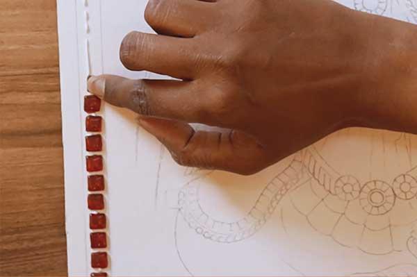 Kundan stones being set by hand on a Tanjore painting