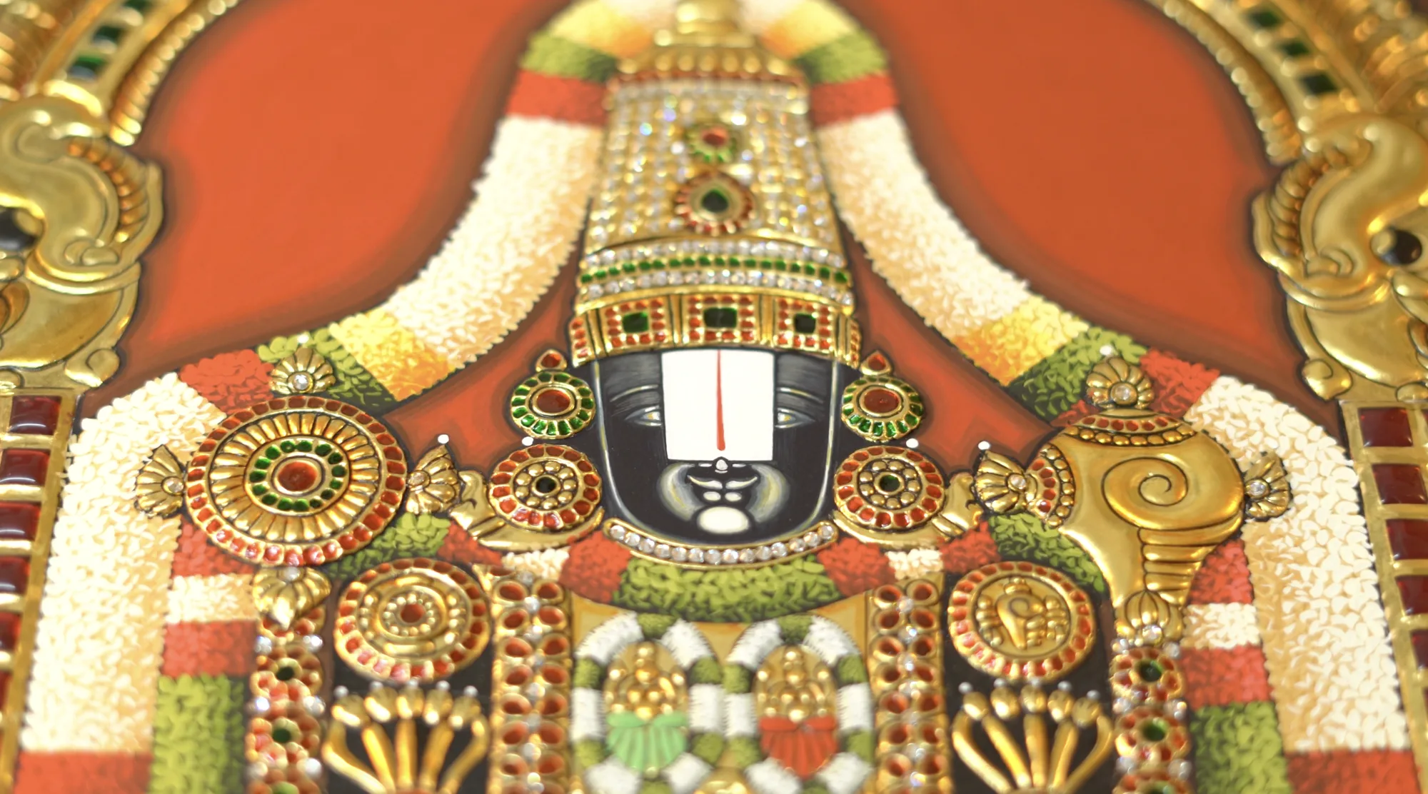 Close-up of the face detailing on a Lord Balaji Tanjore painting