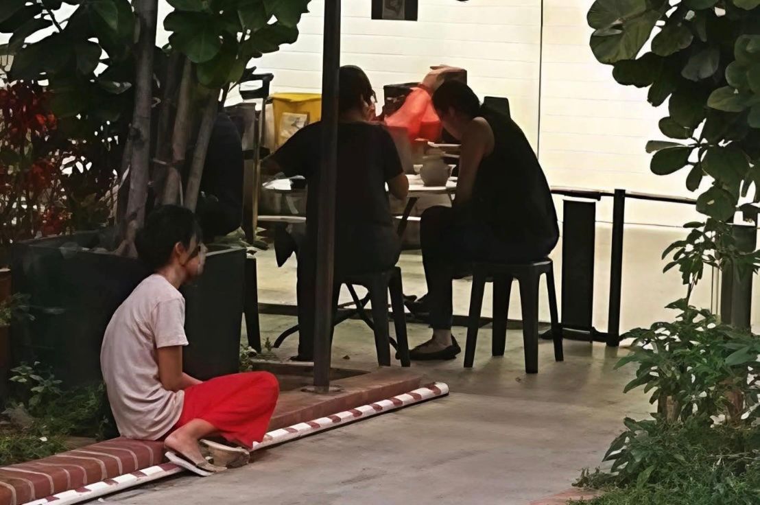 Photo of domestic helper on the ground while employers eat goes viral again; Singaporeans say there are still lessons to be learned