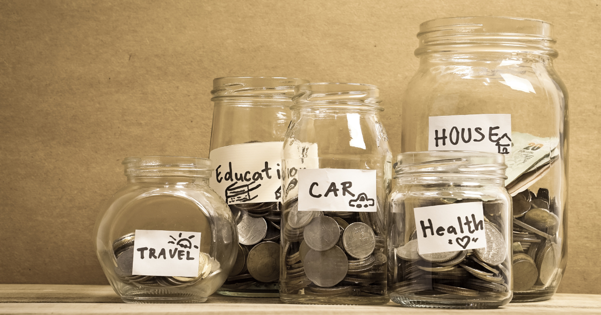  Several glass jars with money in them, each jar labeled with a different savings goal.