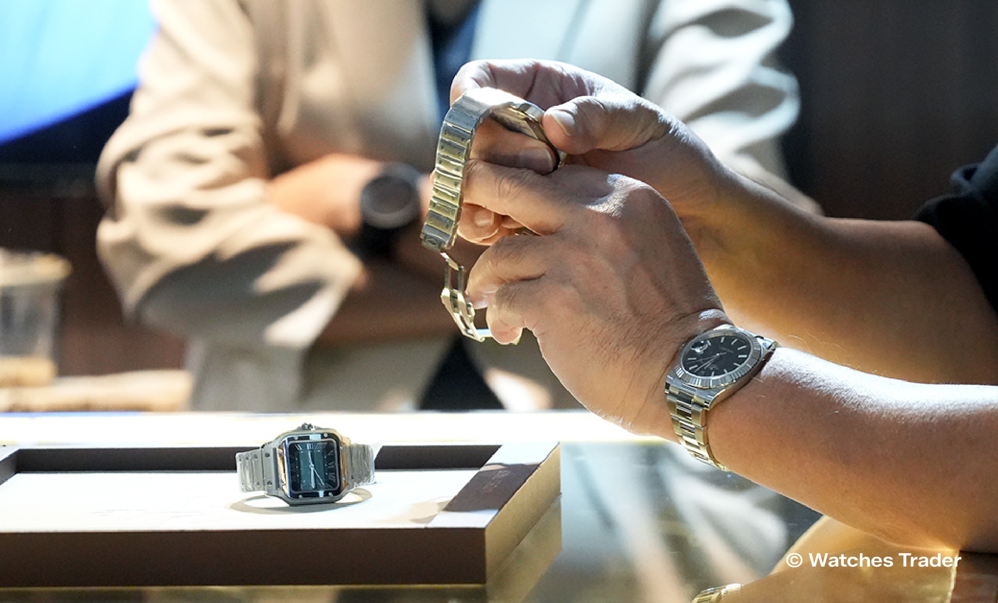 Cartier Santos di atas nampan pajang saat tangan menyesuaikan bracelet jam tangan mewah