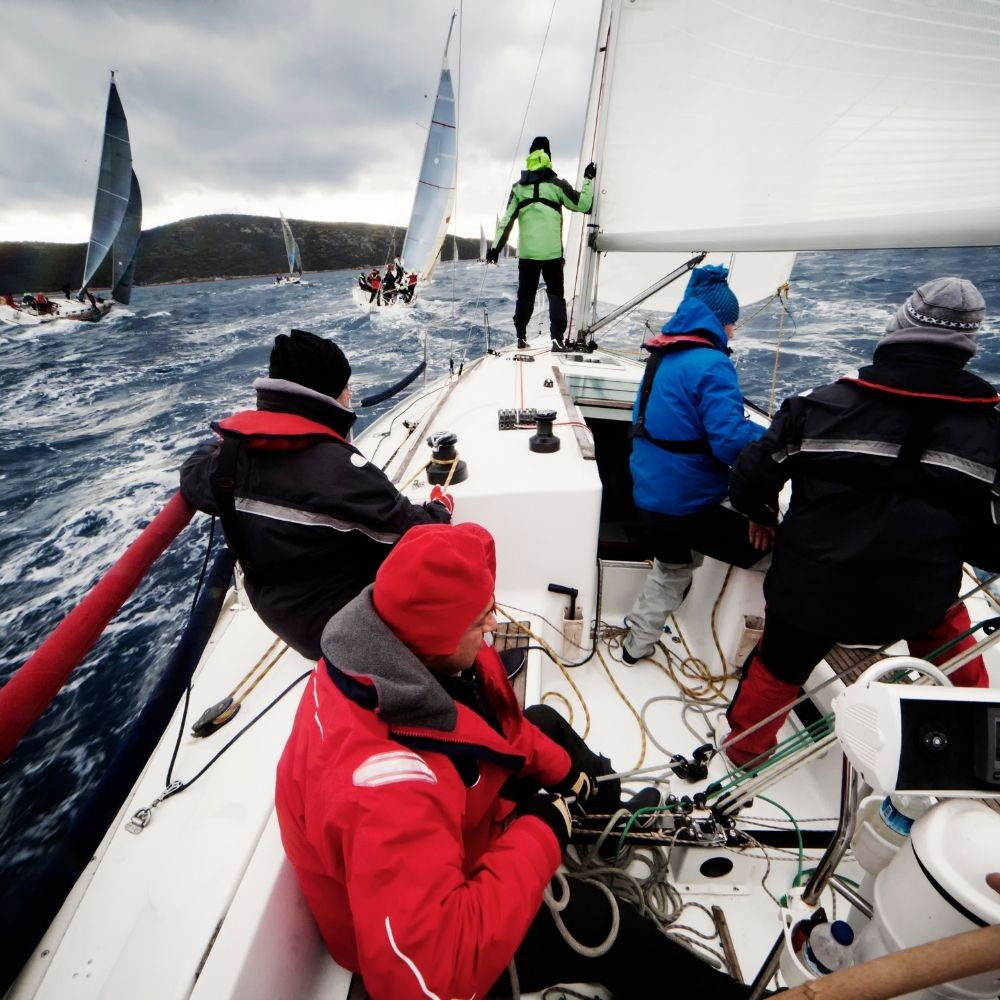 Team crewing a sailing yacht in open water