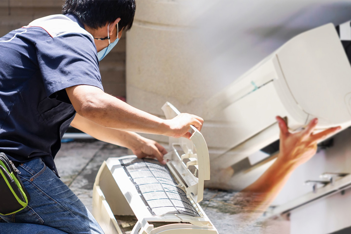 Technician cleaning an indoor aircon unit