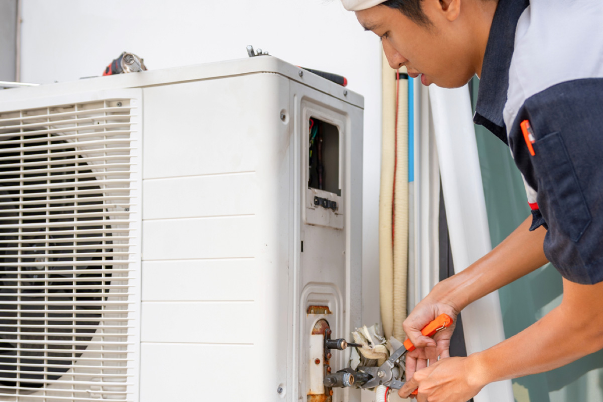 Technician working on an outdoor condenser unit