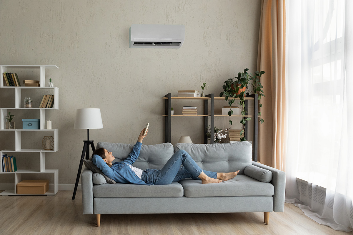 Living room with wall-mounted aircon above a grey sofa