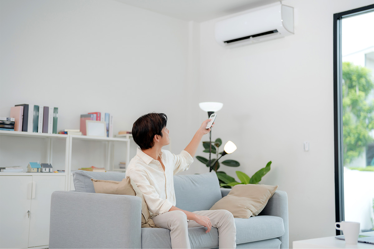 Homeowner using a remote to control a newly installed aircon