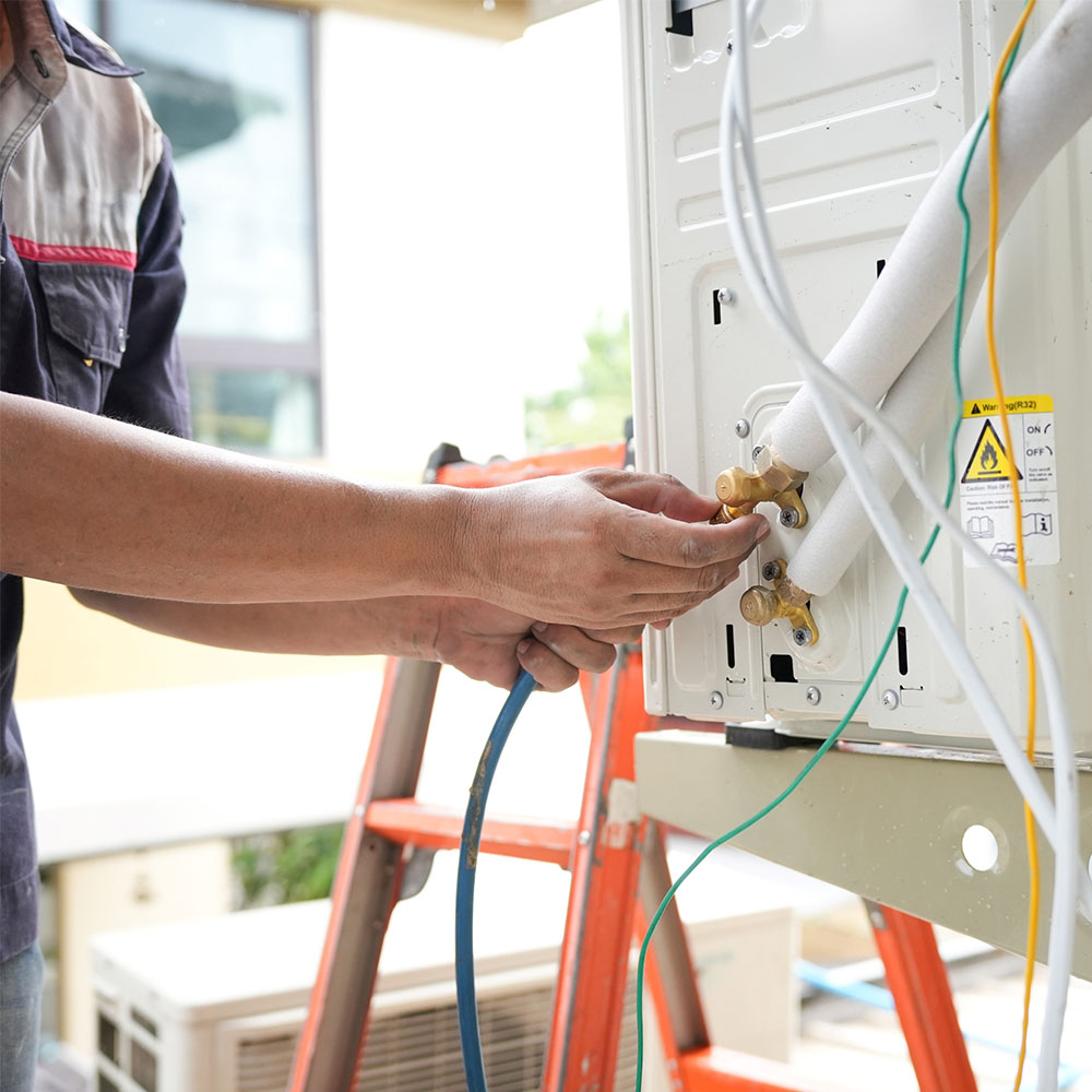 Technician servicing an outdoor air conditioning unit