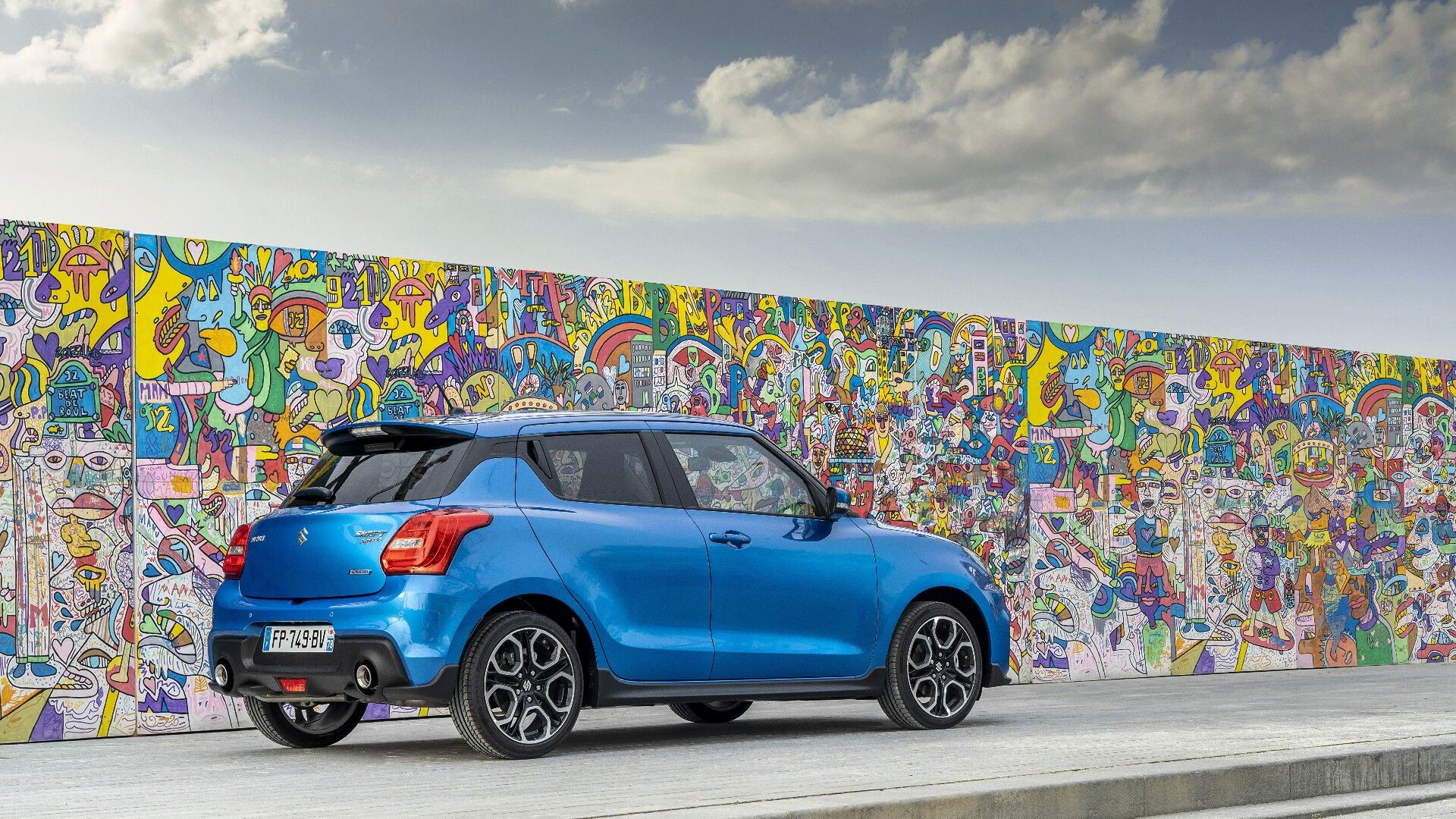 rear view of a Suzuki Swift with a scenic background