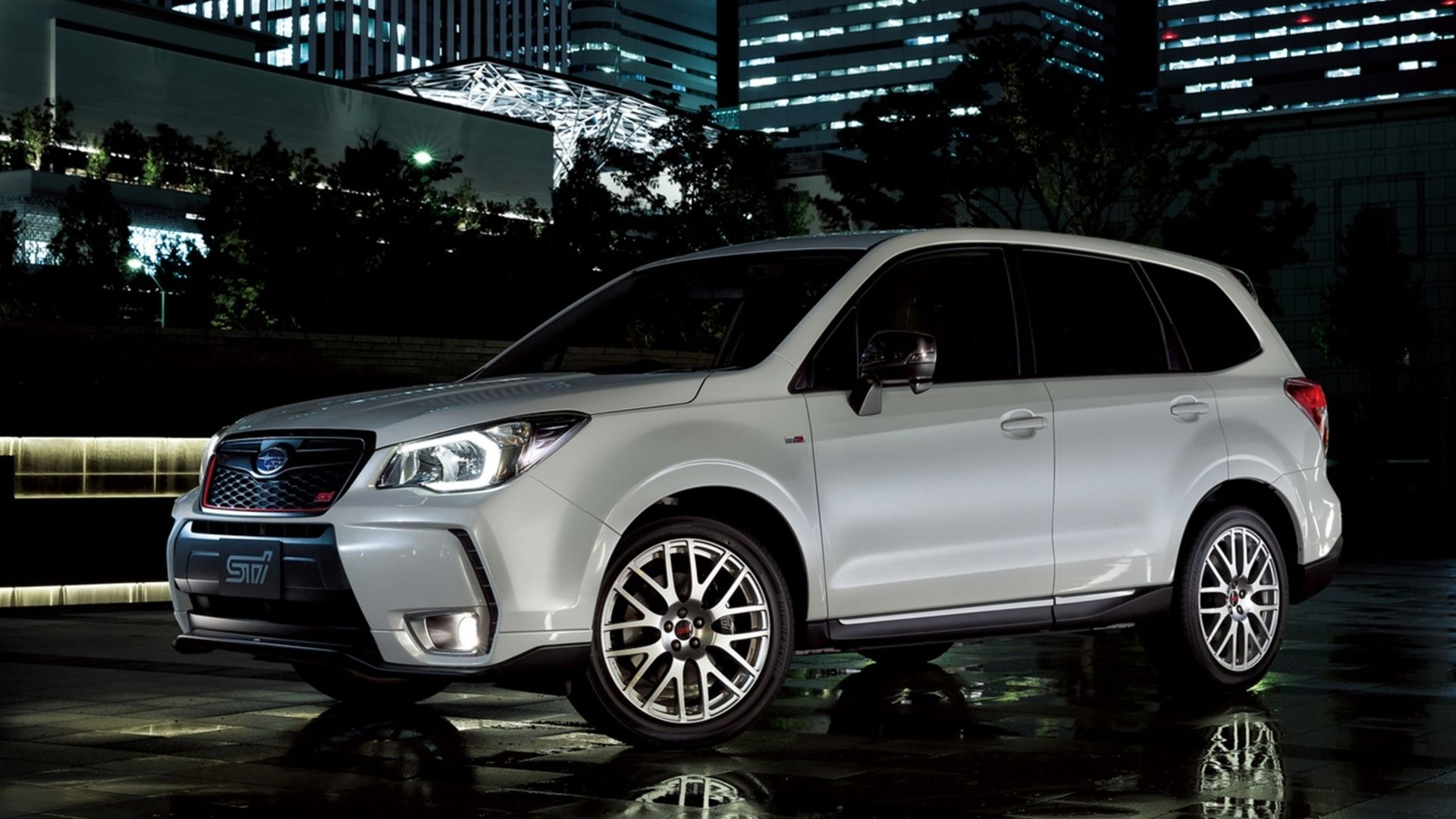 Sideview of a 2014 Subaru Forester tS in the city at night.