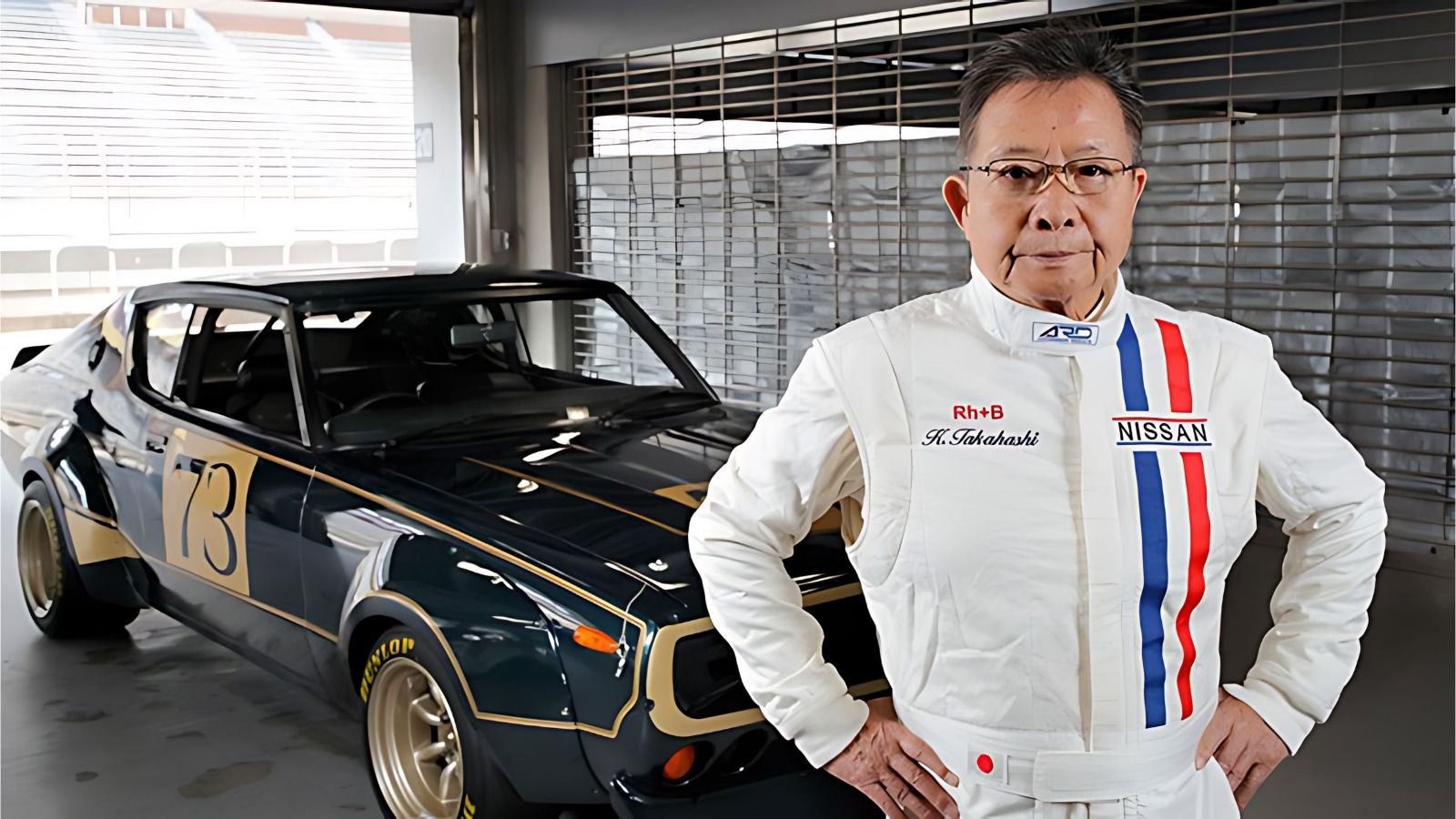 Veteran racer in a Nissan racing suit, standing proudly beside a classic Nissan Skyline GT-R. The car's retro livery and widebody stance highlight its legendary status in the JDM scene.