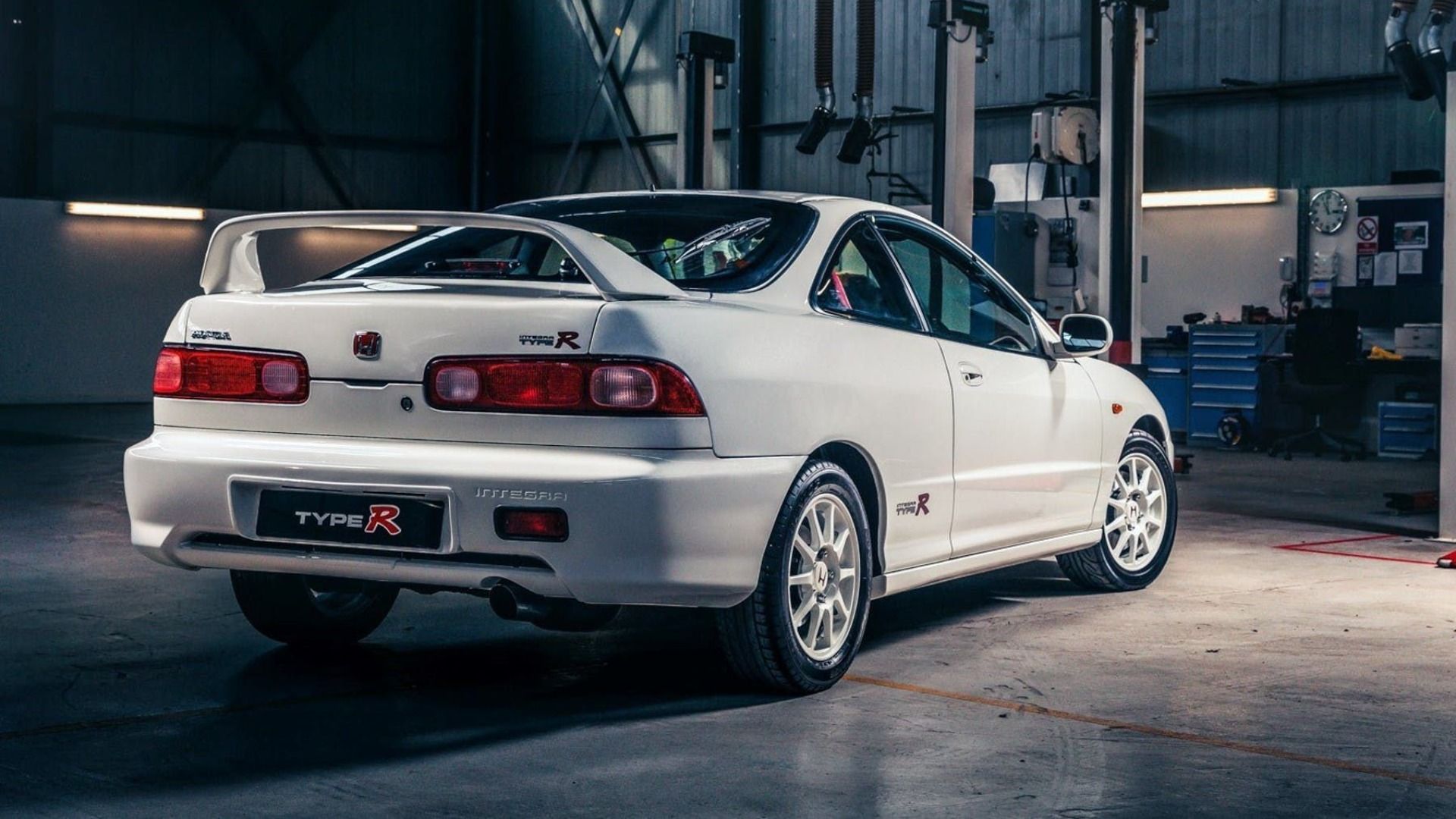 Rear view of a white Honda Integra Type R in a garage.
