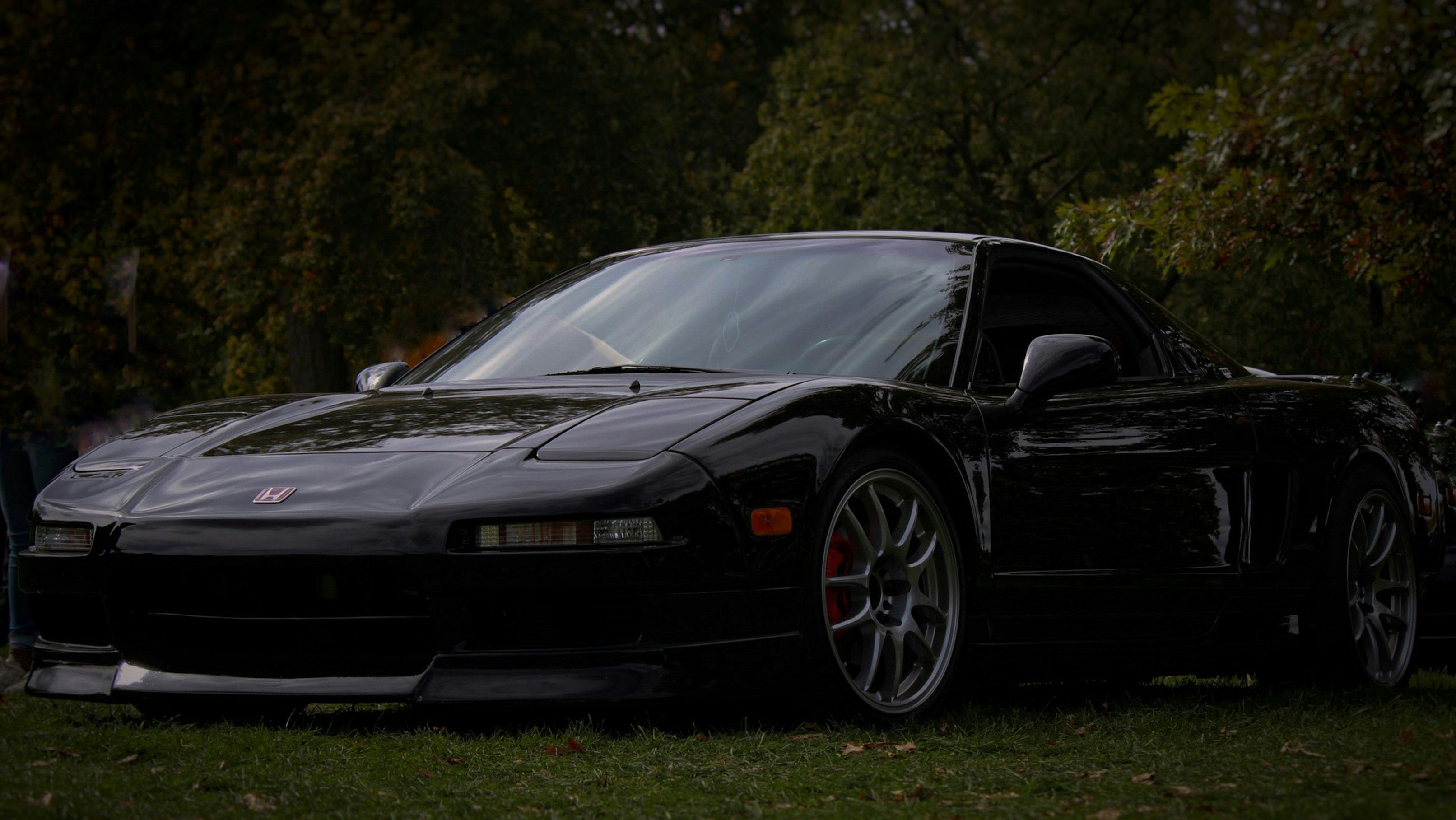 Black Honda NSX with sleek body lines, aggressive stance, and aftermarket wheels, a prime example of JDM engineering excellence.