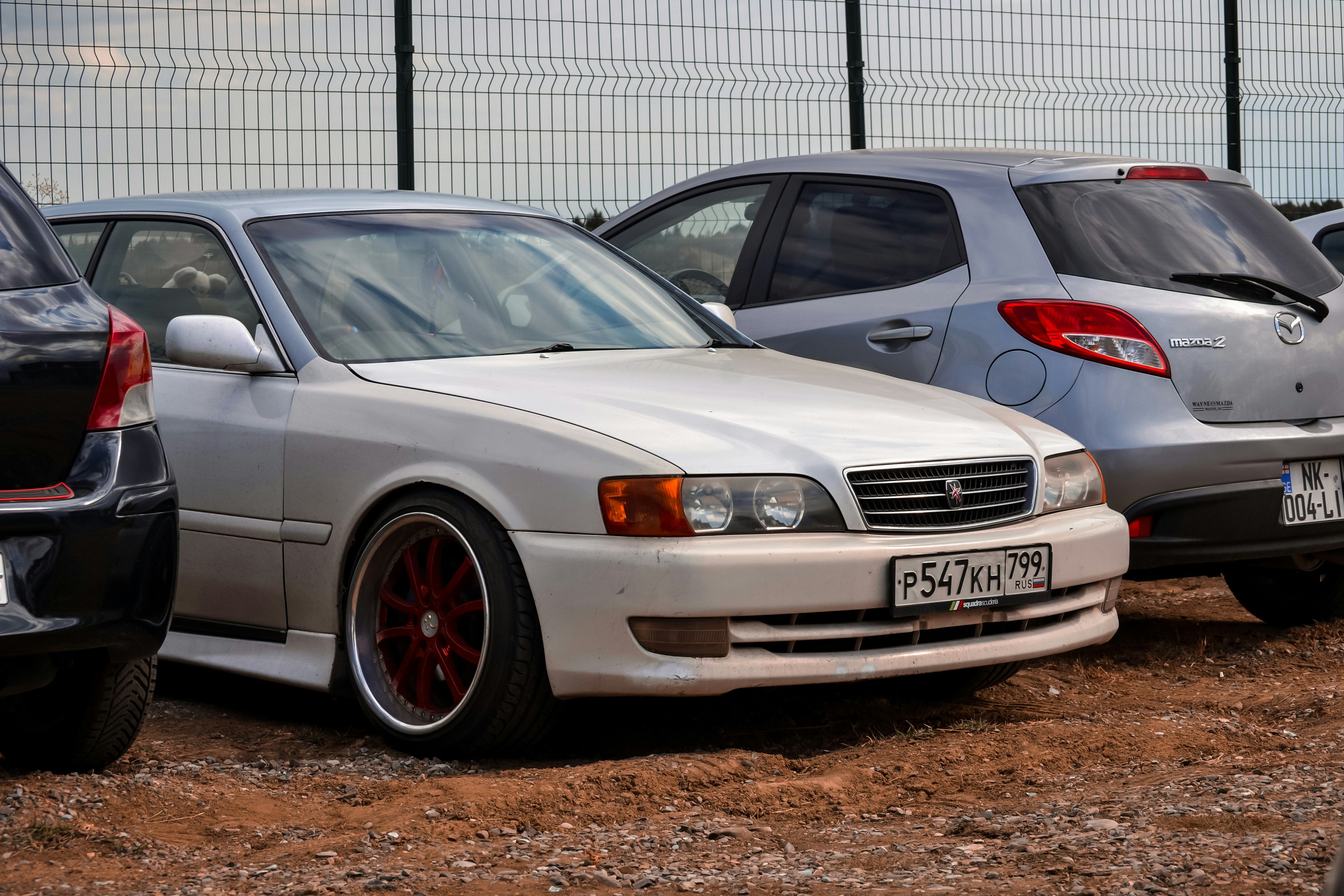Toyota chaser parked next to a toyota vitz and mazda 2