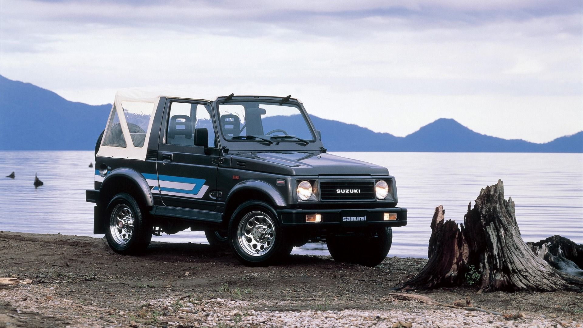 Side view of a Suzuki Jimny near a lake.